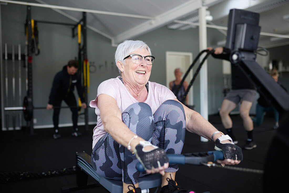 Lächelnde ältere Frau trainiert im Fitnessstudio