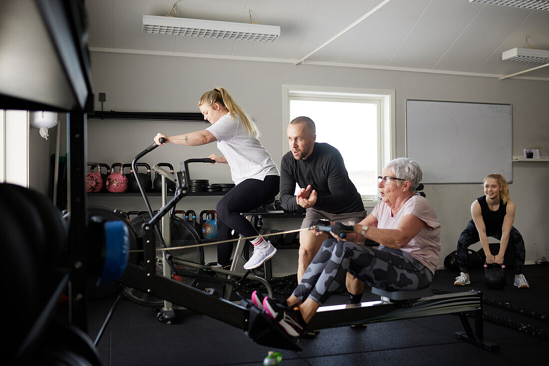 Trainerin hilft Seniorin beim Training im Fitnessstudio