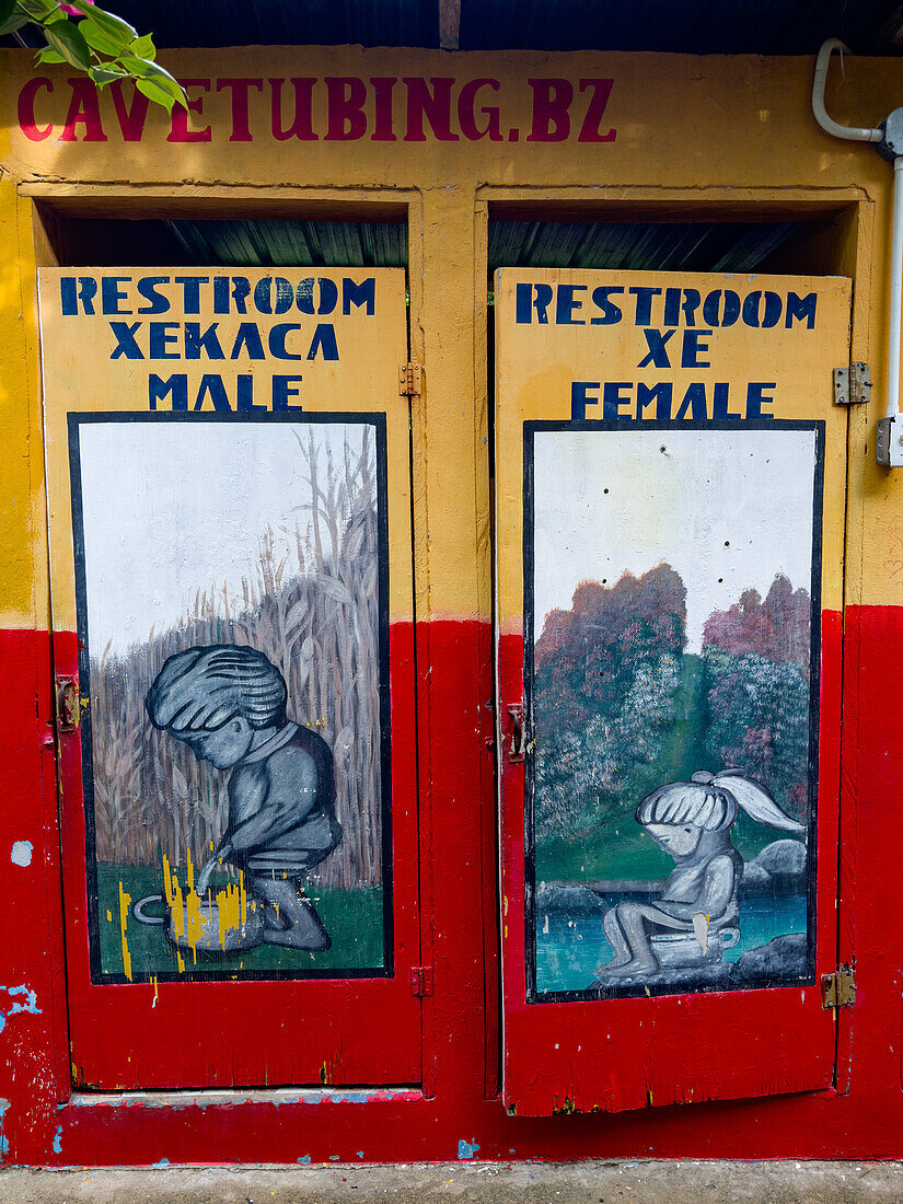Humorvoll bemalte Toilettentüren in einem Cave-Tubing-Tour-Unternehmen im Cayo-Distrikt von Belize.