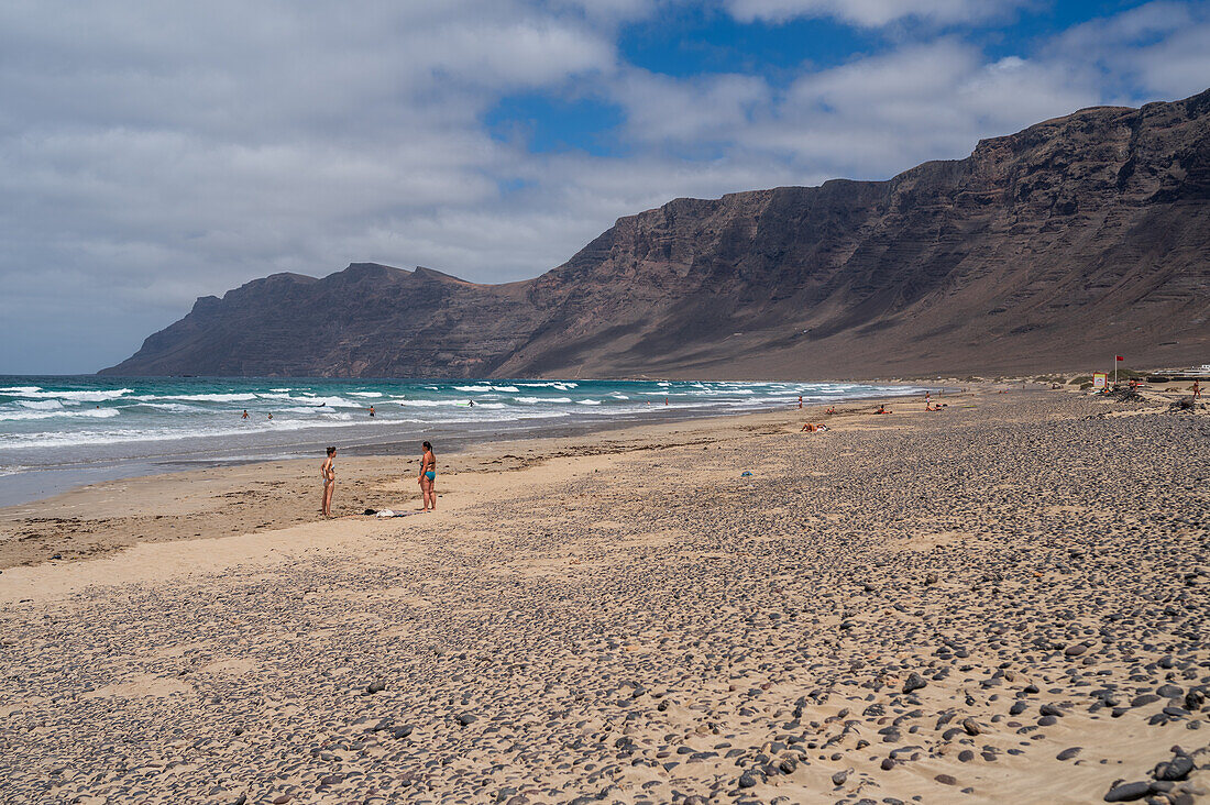 Strand von Famara (Playa de Famara), 6 km langer goldener Sandstrand im Naturpark des Chinijo-Archipels, zwischen dem Fischerdorf La Caleta de Famara und dem Fuß der beeindruckenden Klippen von Famara, Lanzarote, Kanarische Inseln, Spanien