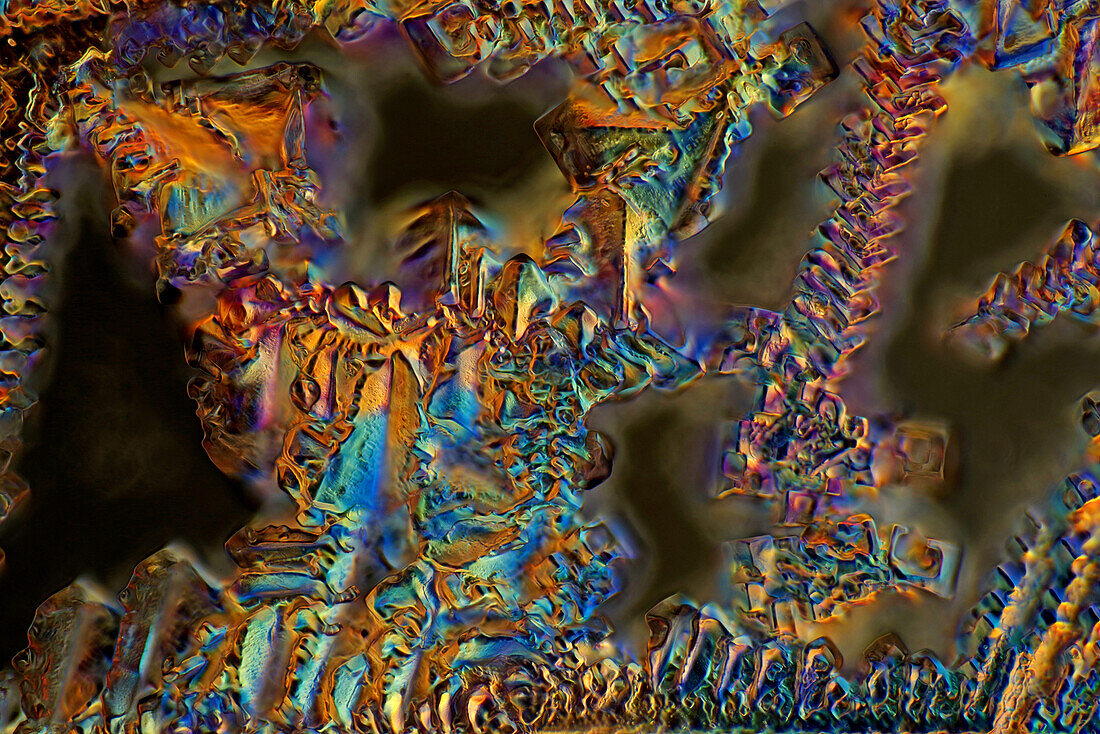 Das Bild zeigt eine kristallisierte Mischung aus Zucker und Salz, fotografiert durch das Mikroskop in polarisiertem Licht bei einer Vergrößerung von 100X