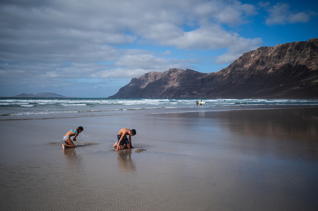 Strand von Famara (Playa de Famara), 6 km langer goldener Sandstrand im Naturpark des Chinijo-Archipels, zwischen dem Fischerdorf La Caleta de Famara und dem Fuß der beeindruckenden Klippen von Famara, Lanzarote, Kanarische Inseln, Spanien