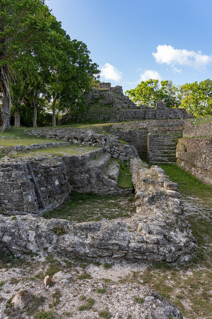 Steinmaske auf der Rückseite von Struktur A2 mit Tempel / Struktur A1 dahinter im archäologischen Reservat Altun Ha, Belize.