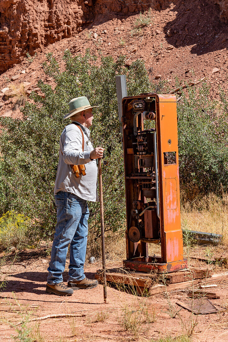 Ein Mann betrachtet eine verfallene Benzinpumpe auf dem Gelände der Big Buck Uranmine im Steen Canyon bei La Sal, Utah.