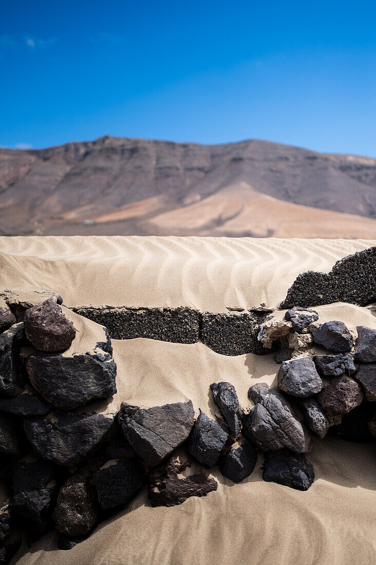 Strand von Famara (Playa de Famara), 6 km langer goldener Sandstrand im Naturpark des Chinijo-Archipels, zwischen dem Fischerdorf La Caleta de Famara und dem Fuß der beeindruckenden Klippen von Famara, Lanzarote, Kanarische Inseln, Spanien