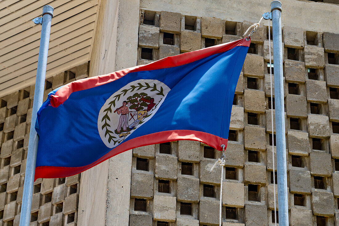 Die Nationalflagge von Belize, die neben dem Gebäude der Nationalversammlung in Belmopan, der Hauptstadt von Belize, weht.