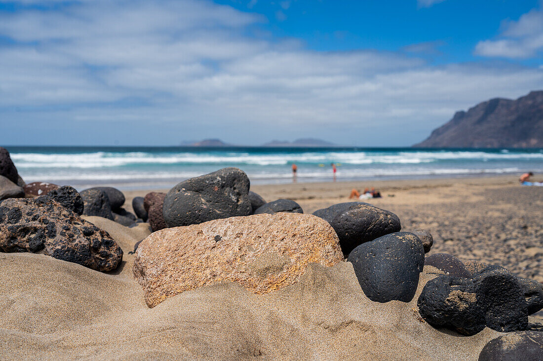 Strand von Famara (Playa de Famara), 6 km langer goldener Sandstrand im Naturpark des Chinijo-Archipels, zwischen dem Fischerdorf La Caleta de Famara und dem Fuß der beeindruckenden Klippen von Famara, Lanzarote, Kanarische Inseln, Spanien