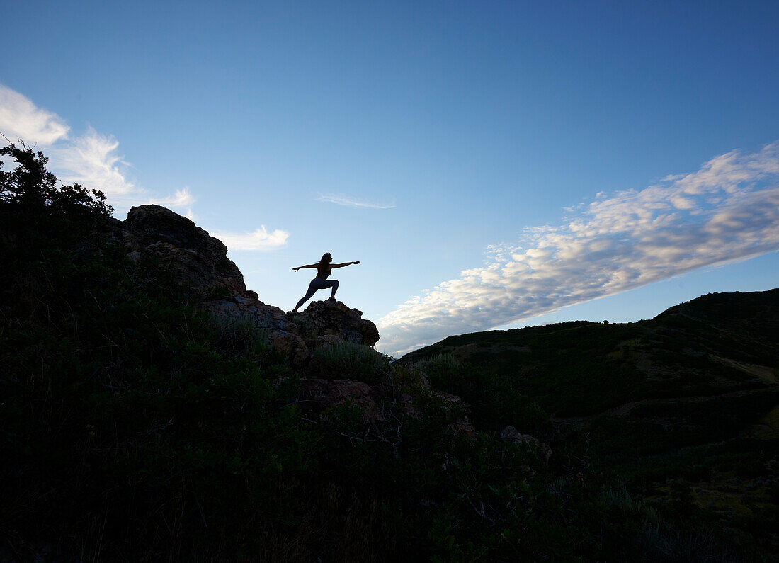 Mid adult woman doing yoga in mountains\n
