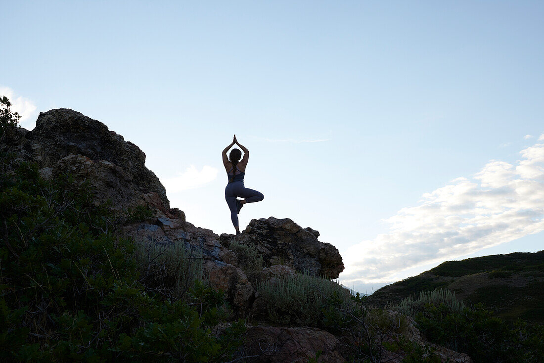 Mid adult woman doing yoga in mountains\n