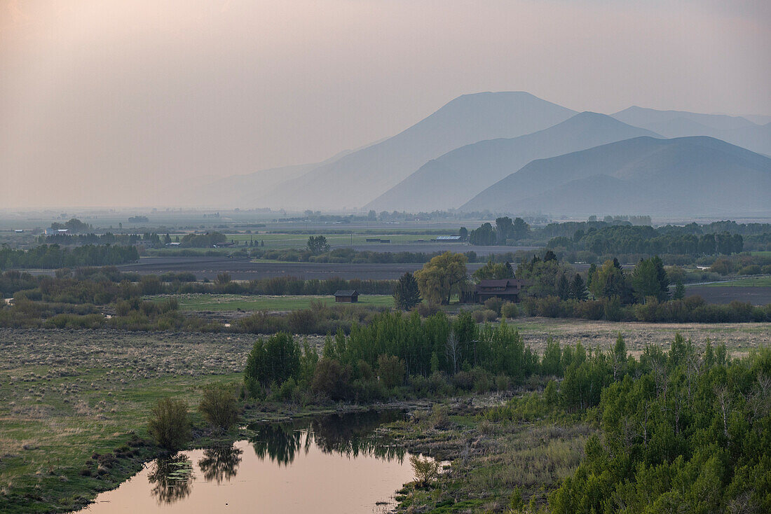 USA, Idaho, Bellevue, Landscape with small pond and mountains in background\n