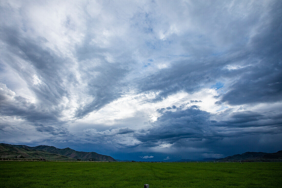 USA, Idaho, Bellevue, Storm clouds above landscape with meadow\n