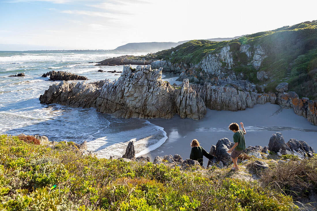 South Africa, Hermanus, Brother (10-11) and sister (16-17) exploring rocky coastline in Voelklip Beach\n