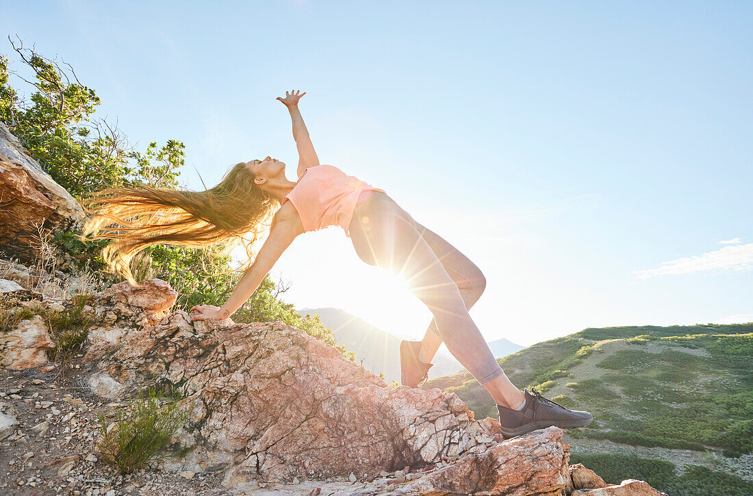 Mid adult woman doing yoga in mountains\n