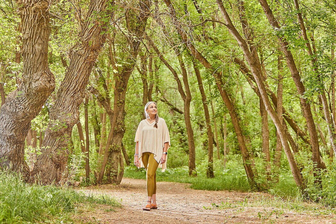 Smiling mature woman walking in park\n