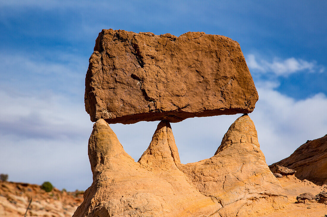 A sandstone block left balanced by erosion in the Orange Cliffs of the Glen Canyon National Recreation Area in Utah.\n