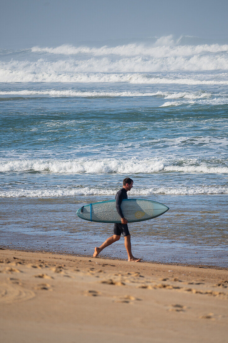 Surfer entering the water.\n