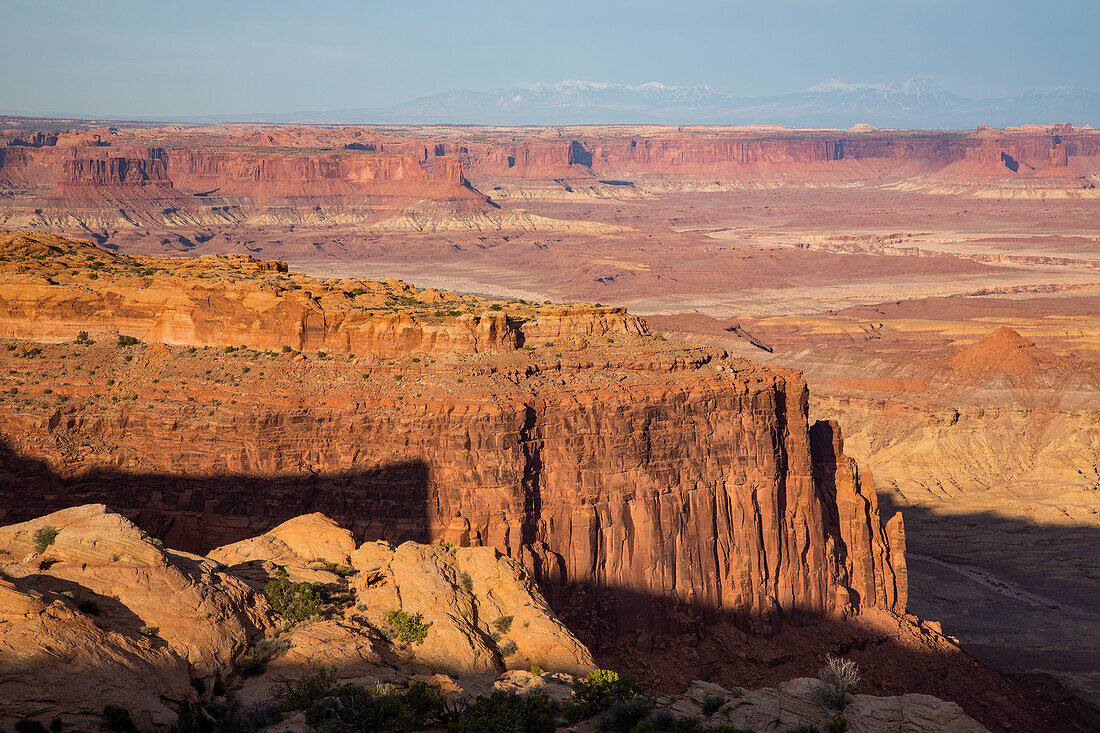 Sandsteinformationen in den Orange Cliffs von Glen Canyon NRA mit dem Green River Basin und dem Canyonlands NP dahinter. Utah. Die La Sal Mountains sind am Horizont zu sehen.