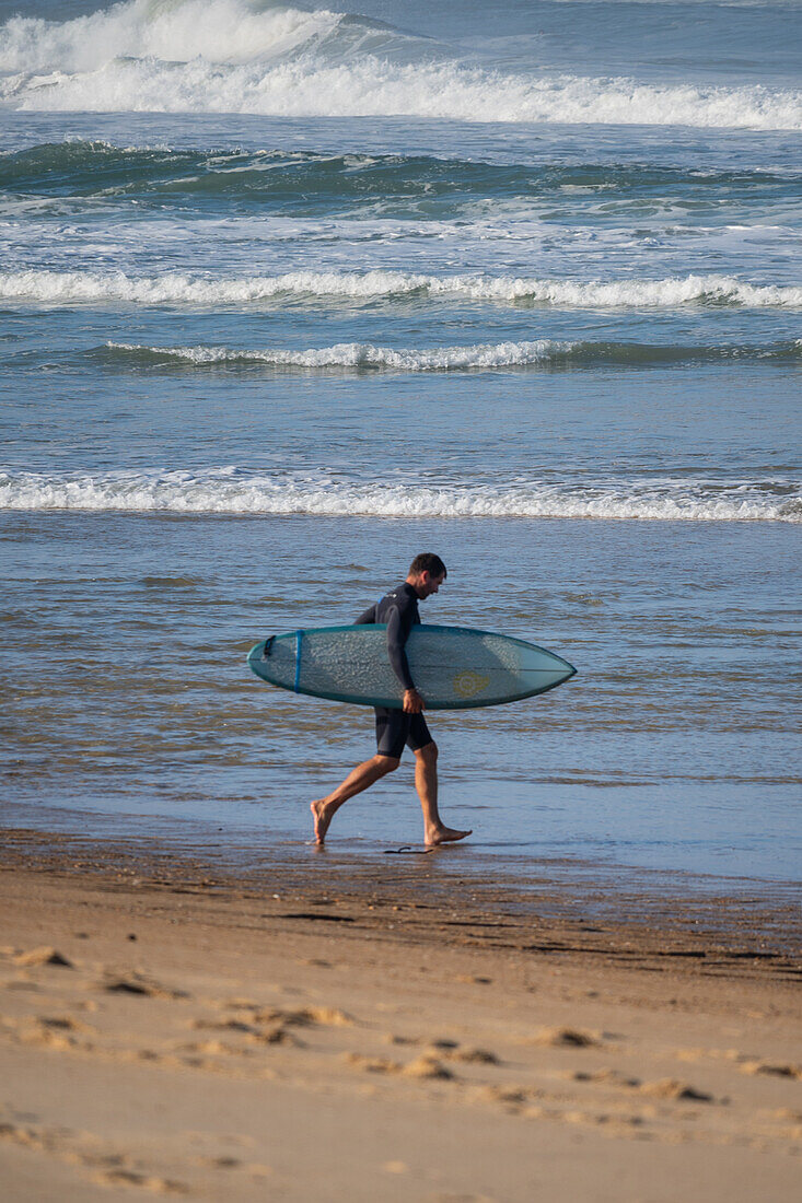 Surfer entering the water.\n