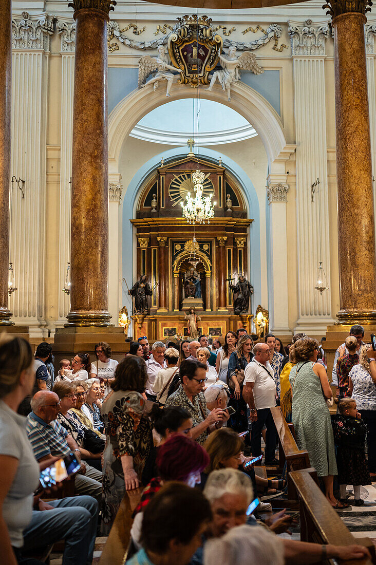 Believers inside the Cathedral-Basilica of Our Lady of the Pillar during The Offering of Flowers to the Virgen del Pilar, the most important and popular event of the Fiestas del Pilar held on Hispanic Day, Zaragoza, Spain\n