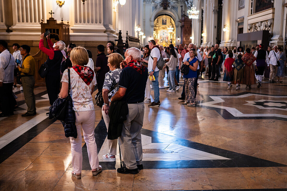 Believers inside the Cathedral-Basilica of Our Lady of the Pillar during The Offering of Flowers to the Virgen del Pilar, the most important and popular event of the Fiestas del Pilar held on Hispanic Day, Zaragoza, Spain\n