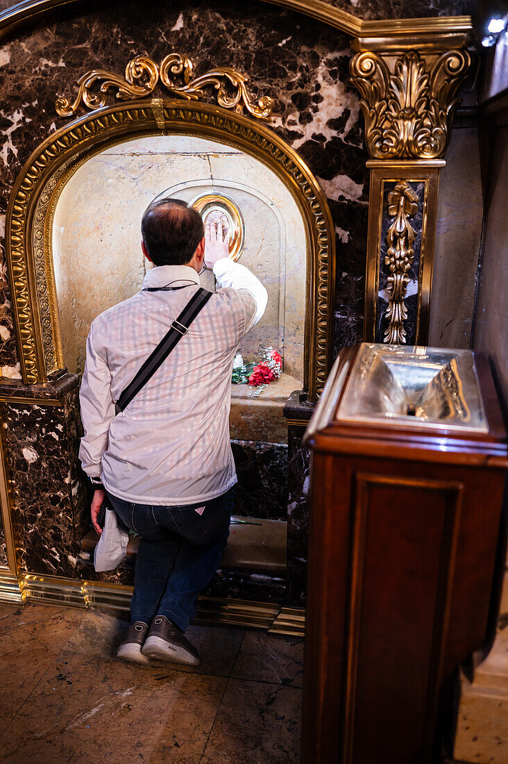 Verehrer küssen die Säule in der Kathedrale-Basilika Unserer Lieben Frau von der Säule während des Blumenopfers für die Virgen del Pilar, der wichtigsten und beliebtesten Veranstaltung der Fiestas del Pilar am Tag der Spanier, Zaragoza, Spanien