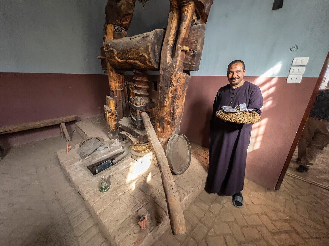 Ein ägyptischer Mann an einer Weinpresse im Herzen der Stadt Dendera, Ägypten, Nordafrika, Afrika