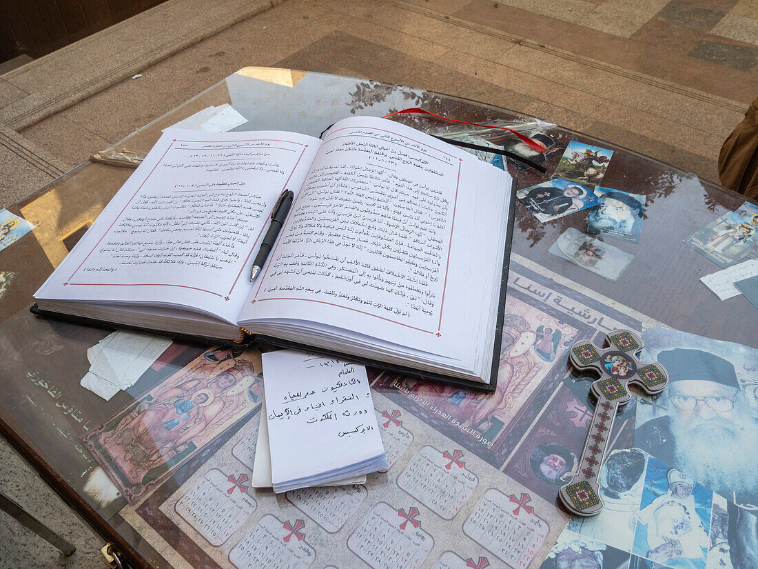 An open ledger book in front of a Catholic Church in the heart of the city of Dendera, Egypt, North Africa, Africa\n