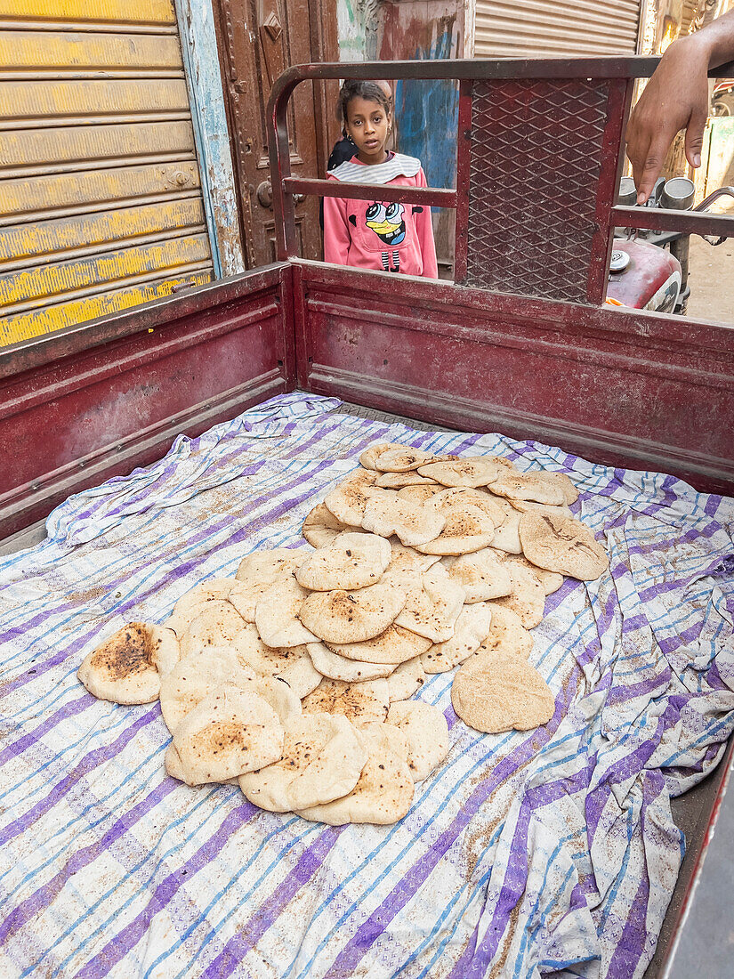 An Egyptian girl at a food cart in the heart of the city of Dendera, Egypt, North Africa, Africa\n