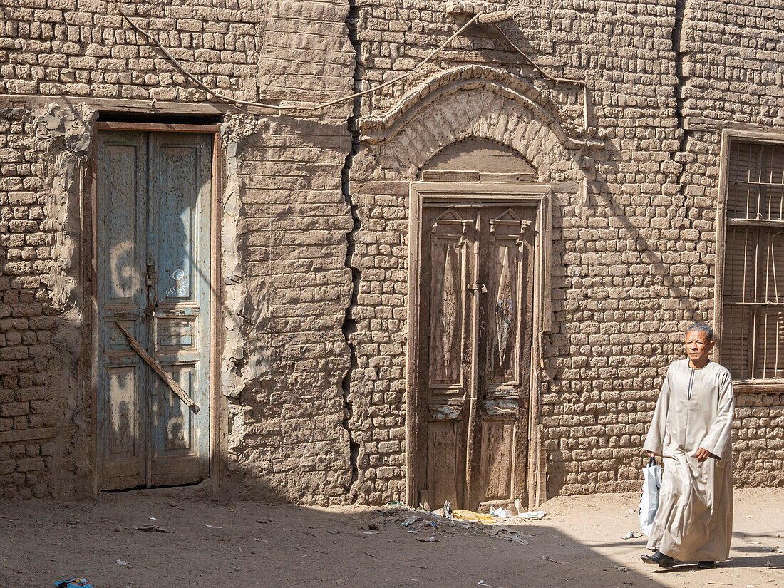 An Egyptian vwalking along the street in the heart of the city of Dendera, Egypt, North Africa, Africa\n