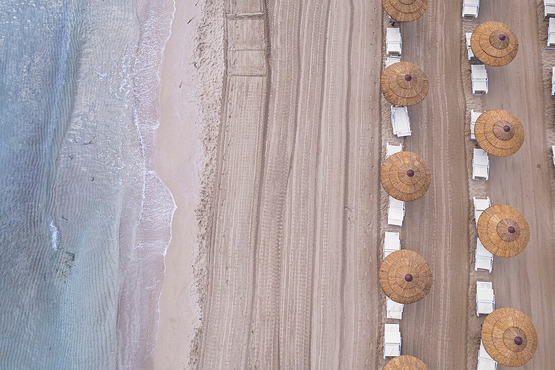 Drohnenansicht von Strohsonnenschirmen an einem leeren Strand, Sizilien, Mittelmeer, Italien, Europa