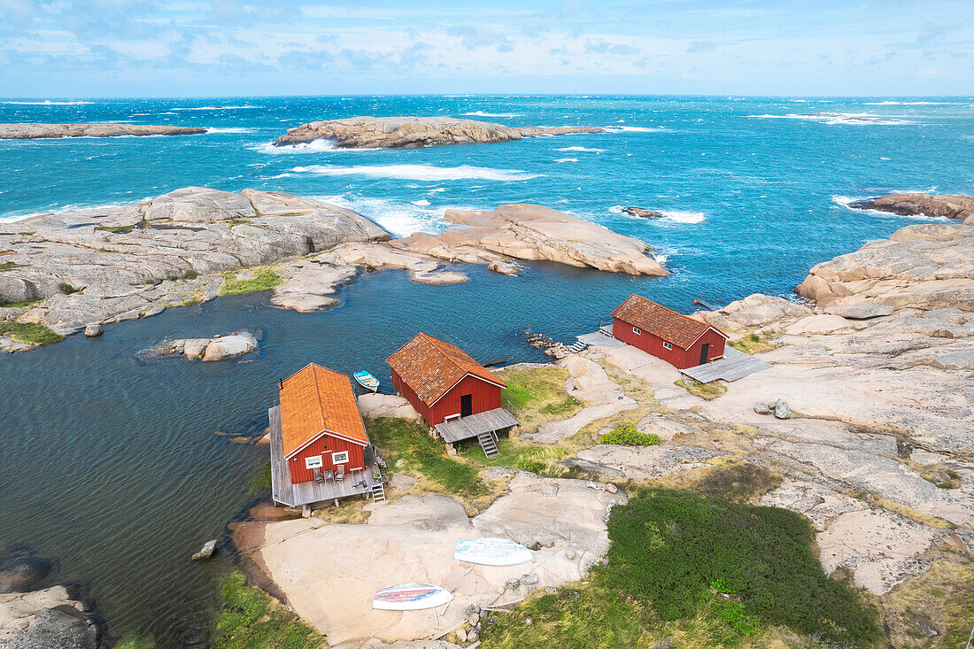 Lonely wooden red cottages on a rocky coast, Bohuslan, Vastra Gotaland, West Sweden, Scandinavia, Europe\n