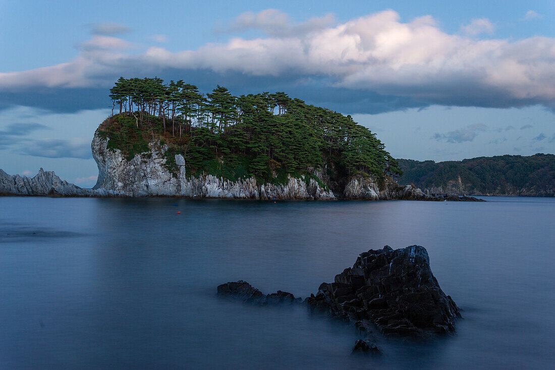 Langzeitbelichtung von Meereslandschaft mit weißer Klippeninsel mit Bäumen in der Ferne, Jodogahama, Präfektur Iwate, Japan, Asien