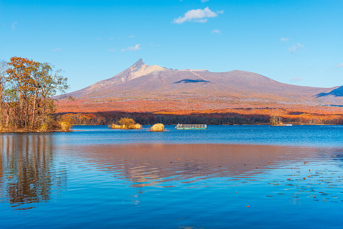 Vibrant autumn colors reflecting in Lake Onuma, with view to Hokkaido Koma-ga-take volcano, Onuma, Hokkaido, Japan, Asia\n