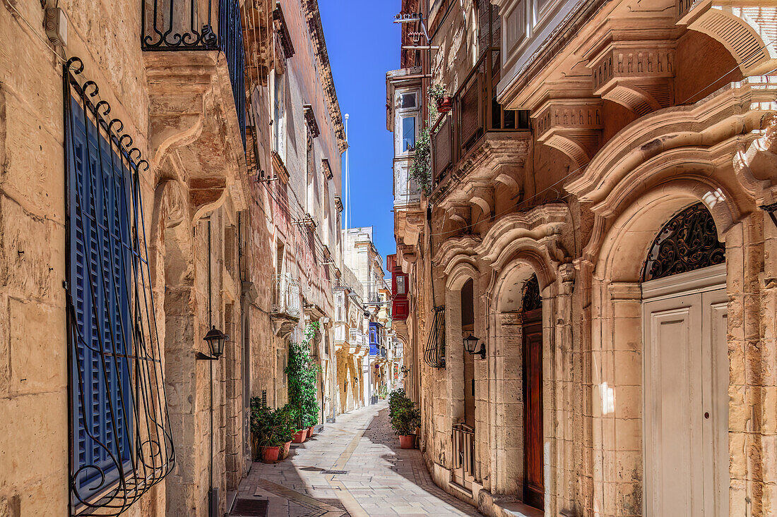 Traditional Maltese limestone buildings with coloured balconies in the vibrant alleys of the old city of Birgu (Citta Vittoriosa), Malta, Mediterranean, Europe\n
