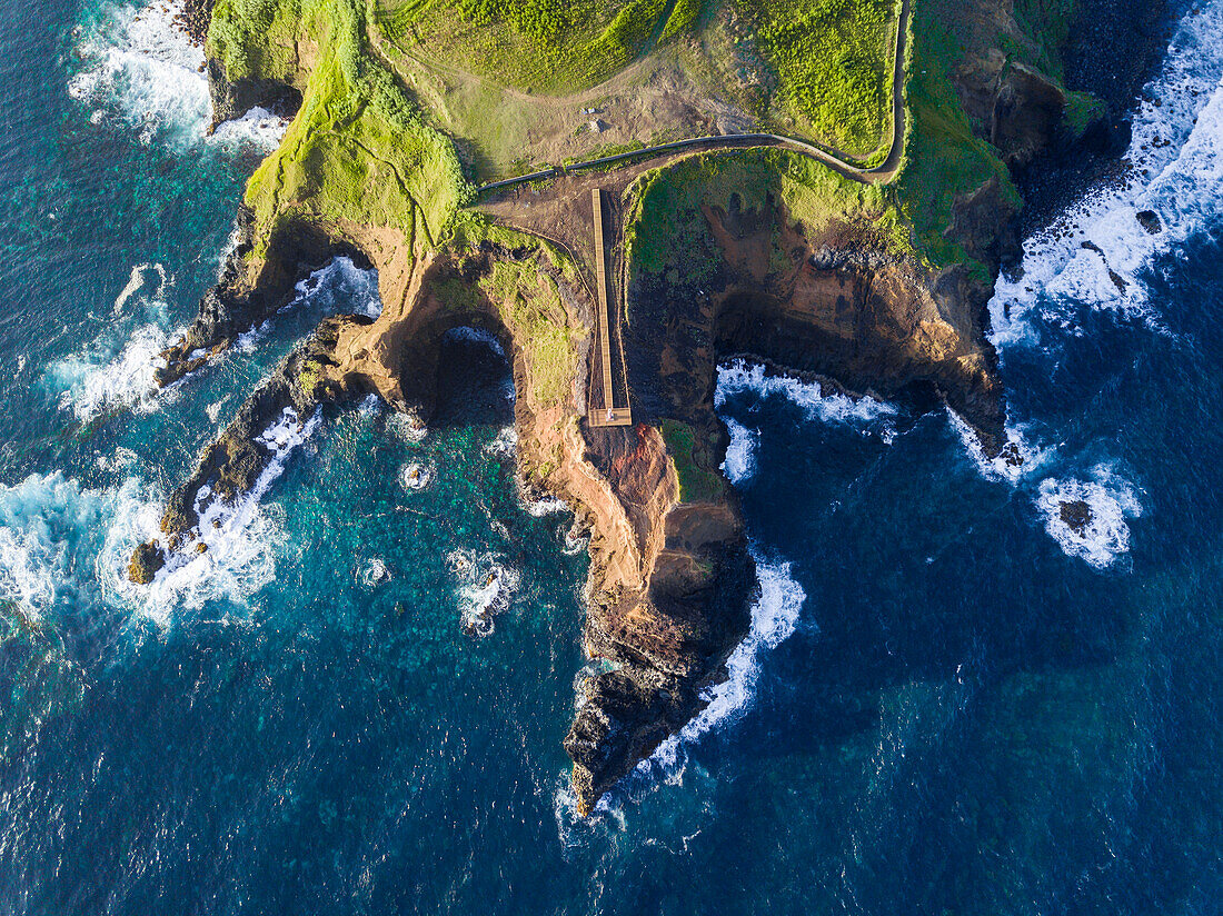 Aerial view of the coasts and cliffs of the island of Sao Miguel over the lighthouse of Farolim dos Fenais da Ajuda, Azores Islands, Portugal, Atlantic, Europe\n