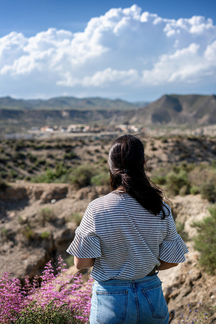 Young woman looking at Tabernas desert on a sunny day, Almeria, Andalusia, Spain, Europe\n