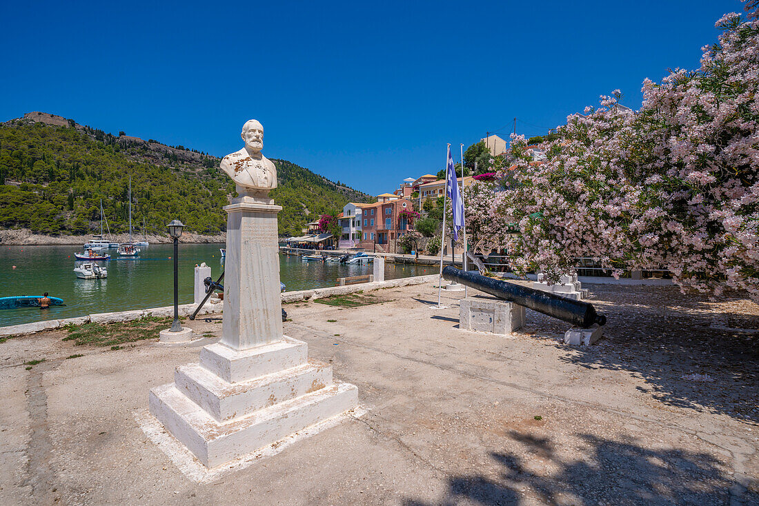 View of statue and colourful houses in Assos, Assos, Kefalonia, Ionian Islands, Greek Islands, Greece, Europe\n