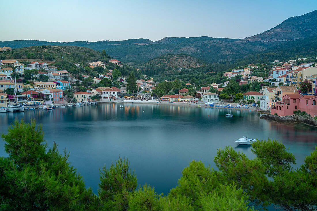 Elevated view of harbour and colourful houses in Assos at dusk, Assos, Kefalonia, Ionian Islands, Greek Islands, Greece, Europe\n
