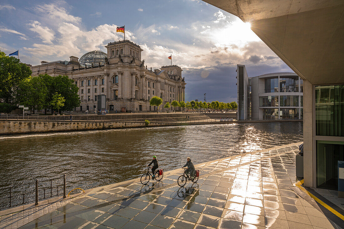 View of cyclists and River Spree and the Reichstag (German Parliament building), Mitte, Berlin, Germany, Europe\n
