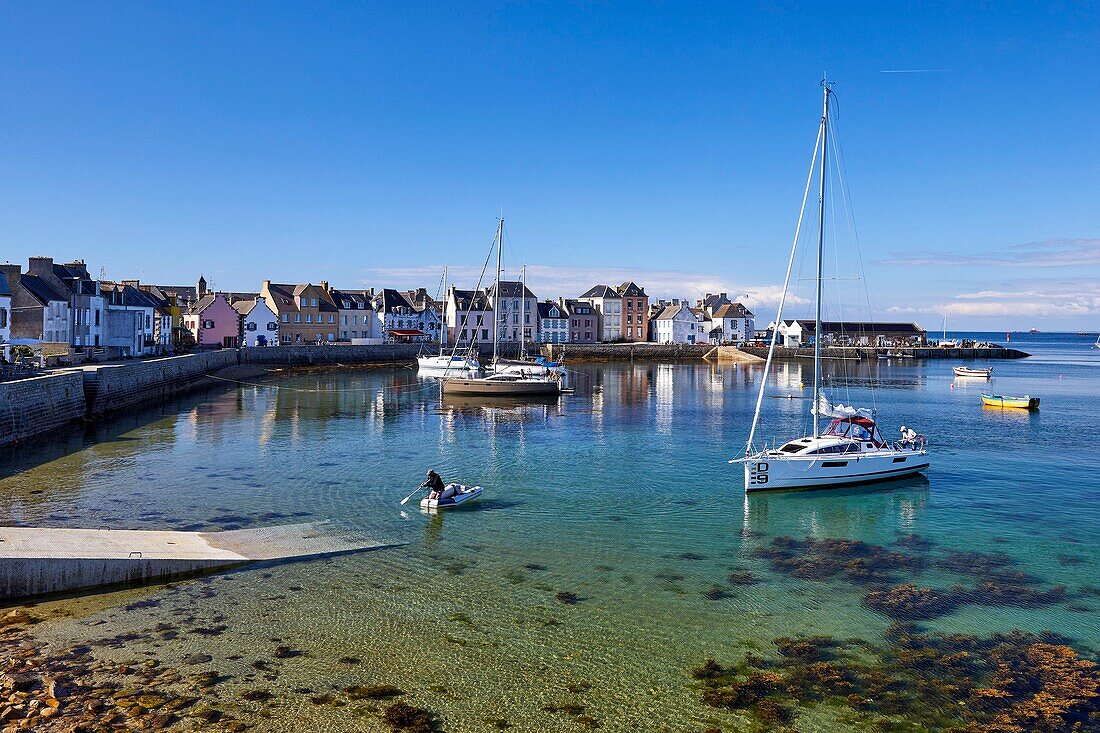 France, Finistere, Ile de Sein, sailboats at anchor in the port at high tide in front of the quai des Français Libres\n