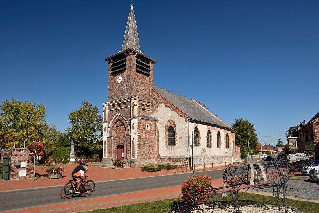 France, Nord, Genech, Notre Dame de la Visitation church rebuilt in the middle of the 16th century, two bikers on the road\n