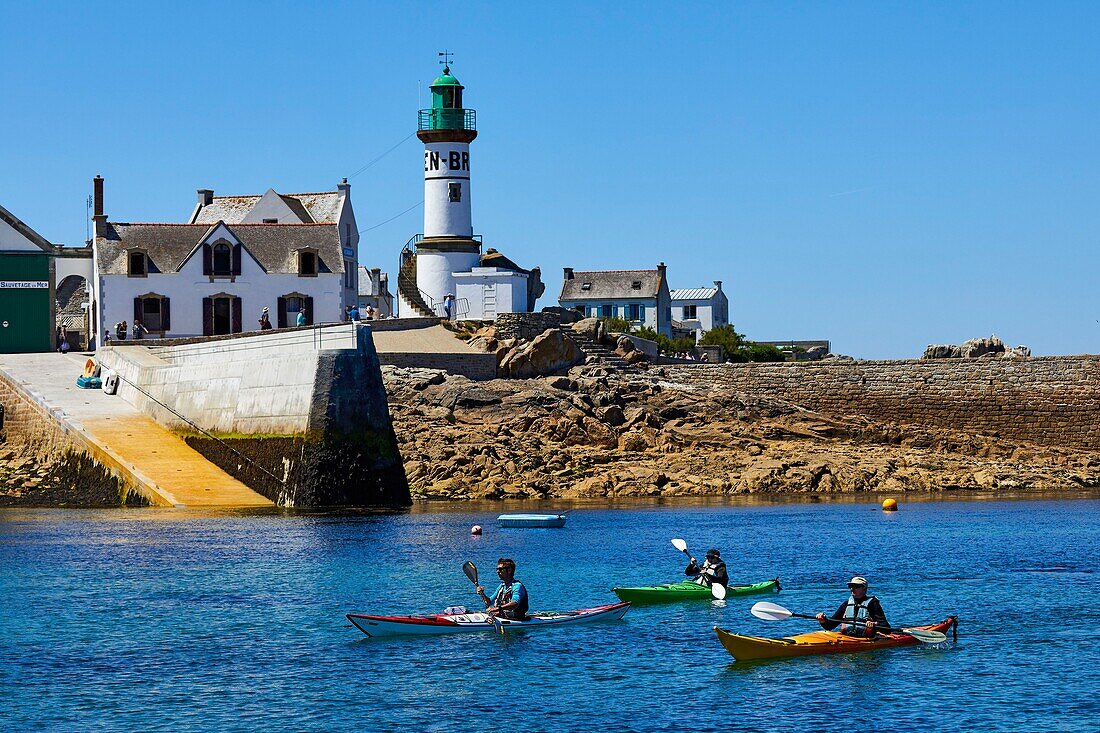 France, Finistere, Ile de Sein, kayak in the harbour in front of the Men-Brial lighthouse\n