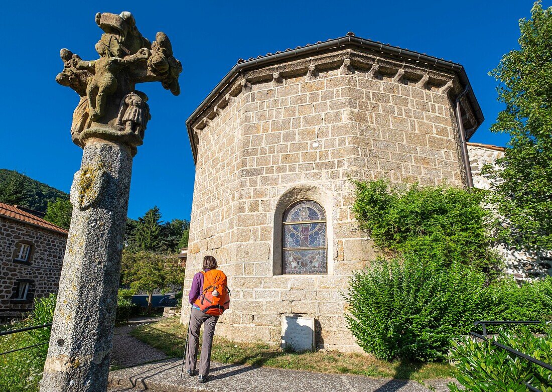 France, Haute-Loire, Monistrol d'Allier, hike on Via Podiensis, one of the French pilgrim routes to Santiago de Compostela or GR 65, 12th century Saint-Pierre church and a 15th century stone cross\n