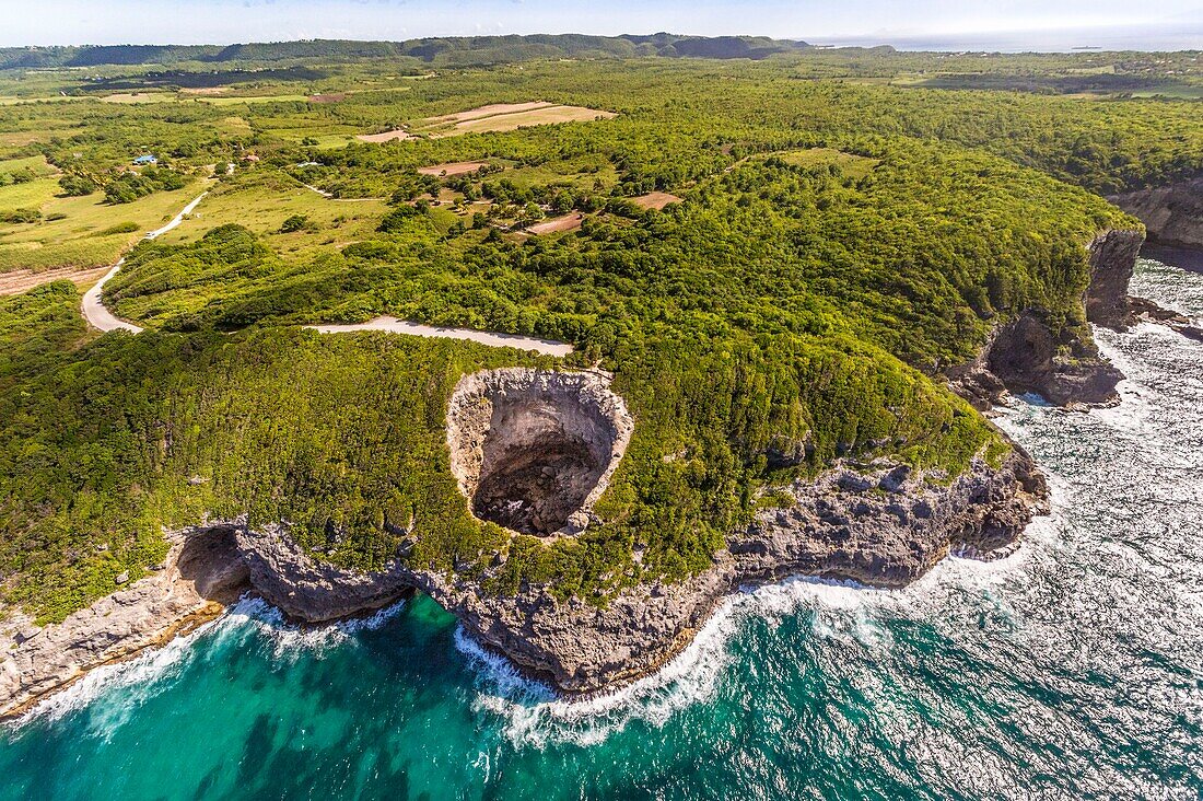 France, Caribbean, Lesser Antilles, Guadeloupe, Marie-Galante, Saint-Louis, aerial view of the Gueule Grand Gouffre (50 m high), a natural arch dug by the sea\n