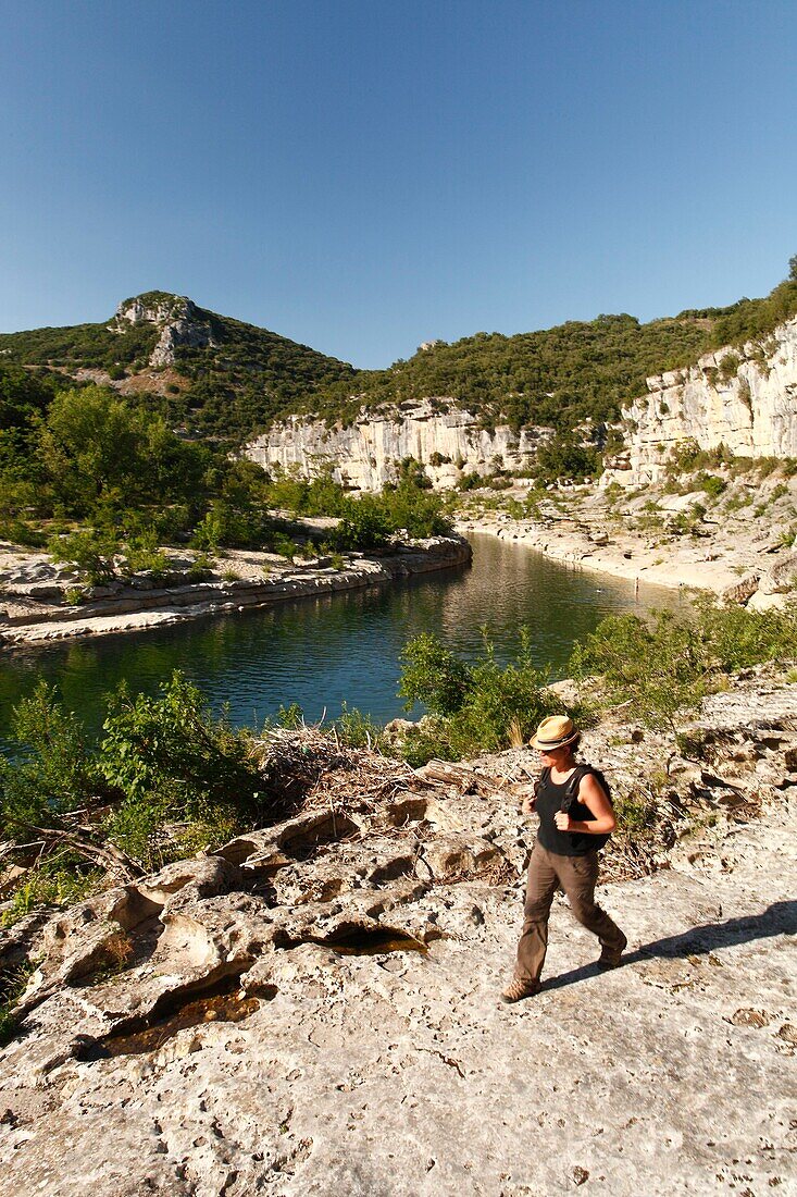 France, Ardeche, Ardeche Gorges National Natural Reserve, Sauze, Female hiker above Ardeche river, on the path of the Louby valley\n