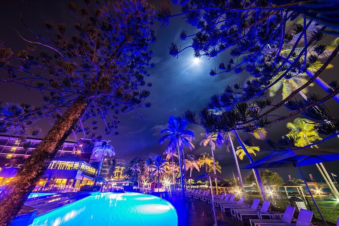France, Caribbean, Lesser Antilles, Guadeloupe, Grande-Terre, Le Gosier, Creole Beach's garden and swimming pool by moonlight\n