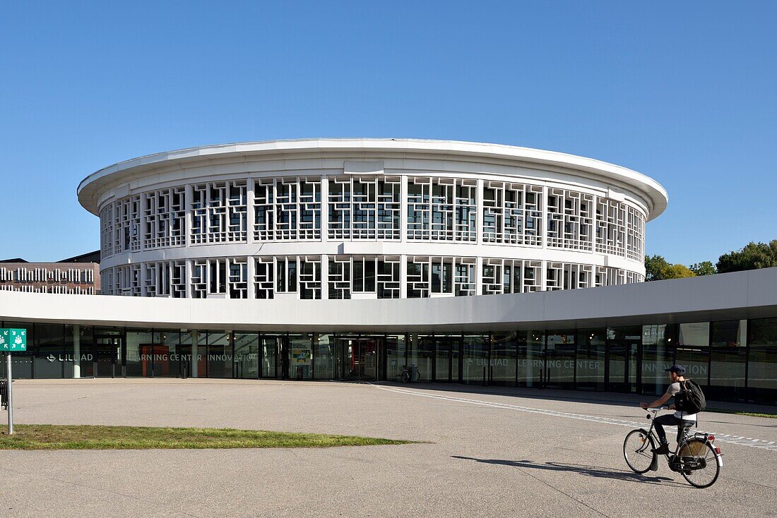 France, Nord, Villeneuve d'Ascq, University of Lille, Cité Scientifique campus, circular building housing the library and called LILLIAD (Learning Center Innovation1), a scientific center of the University of Lille (scientific university library, multimedia, large scientific collection, expanded library and digitized resources), cycling student\n