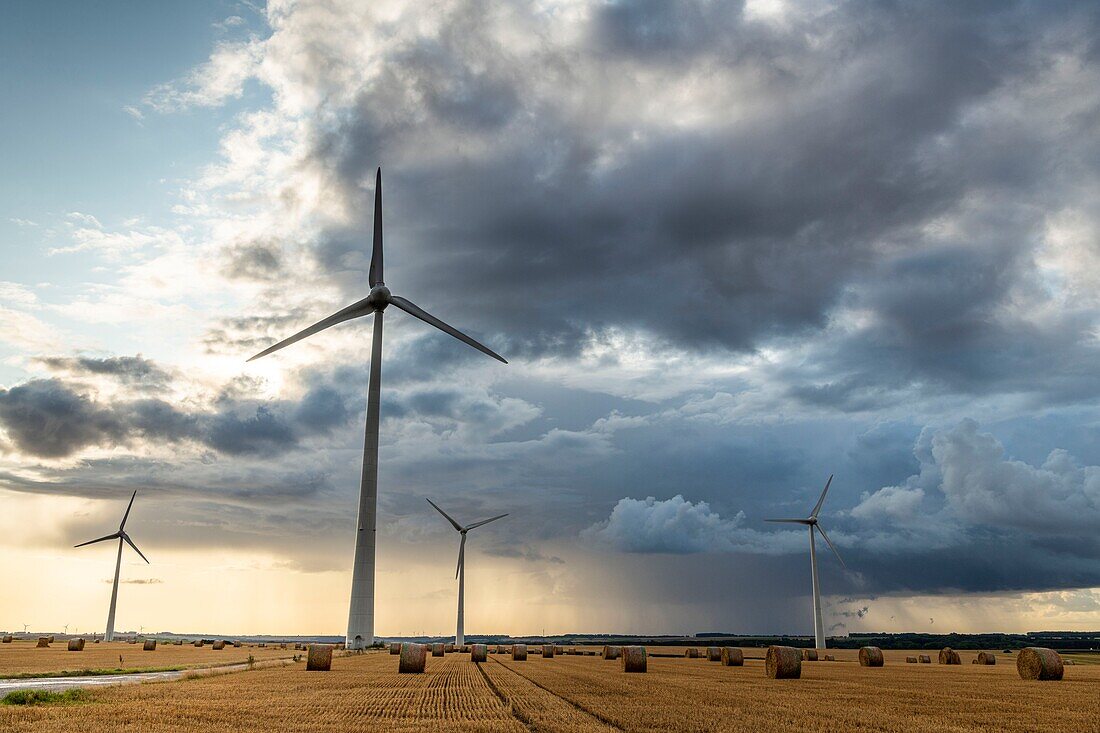 France, Somme, Nampont-Saint-Martin, wind turbines on stormy sky background\n