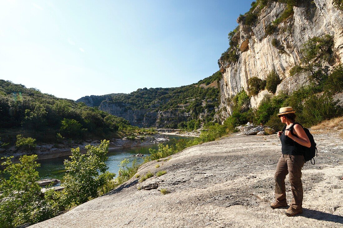 France, Ardeche, Ardeche Gorges National Natural Reserve, Sauze, Female hiker above Ardeche river, on the path of the Louby valley\n