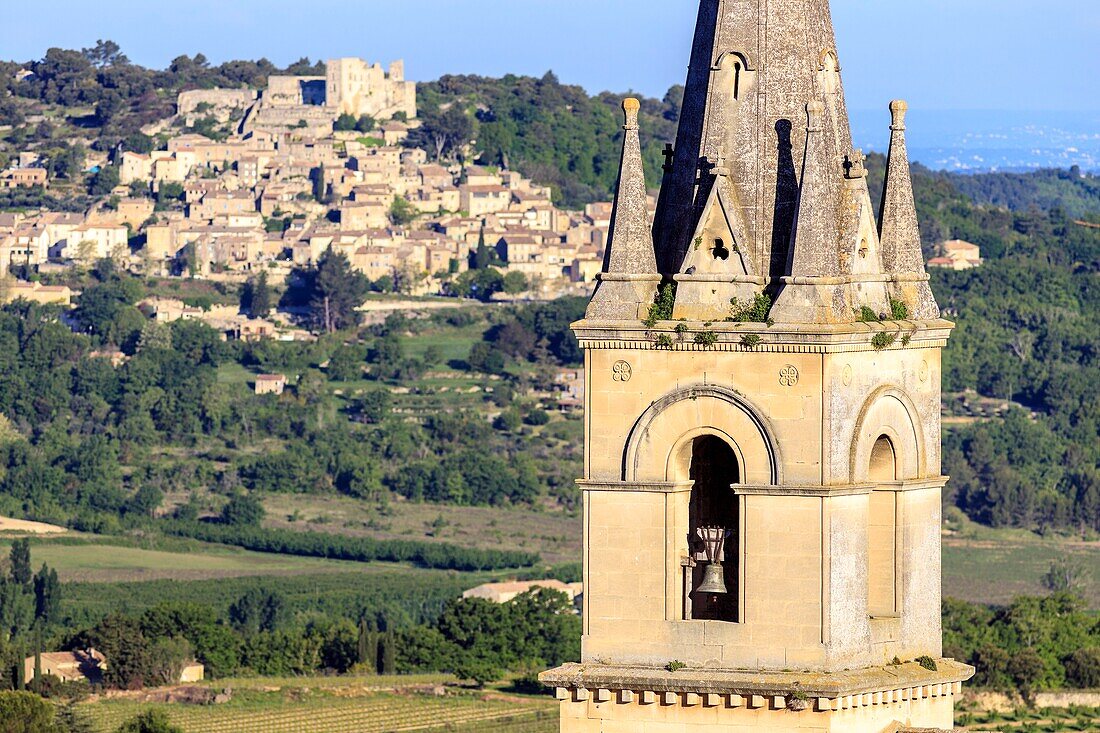 France, Vaucluse, regional natural reserve of Luberon, Bonnieux, steeple of the new church and the village of Lacoste in the background\n